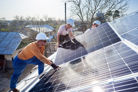 Solar panel installers on a roof